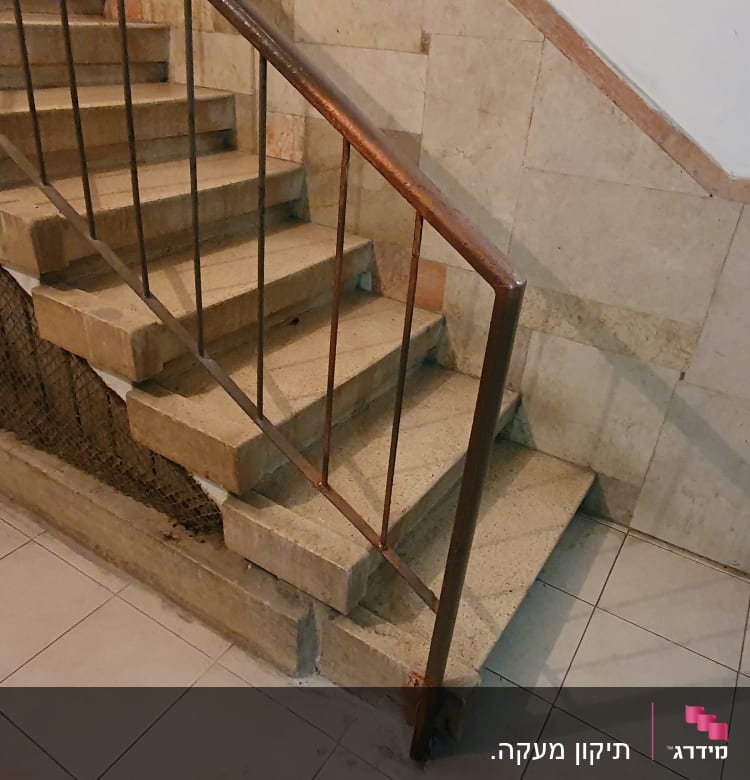 מדרגות אבן עם מעקה מתכת ורשת בטיחות